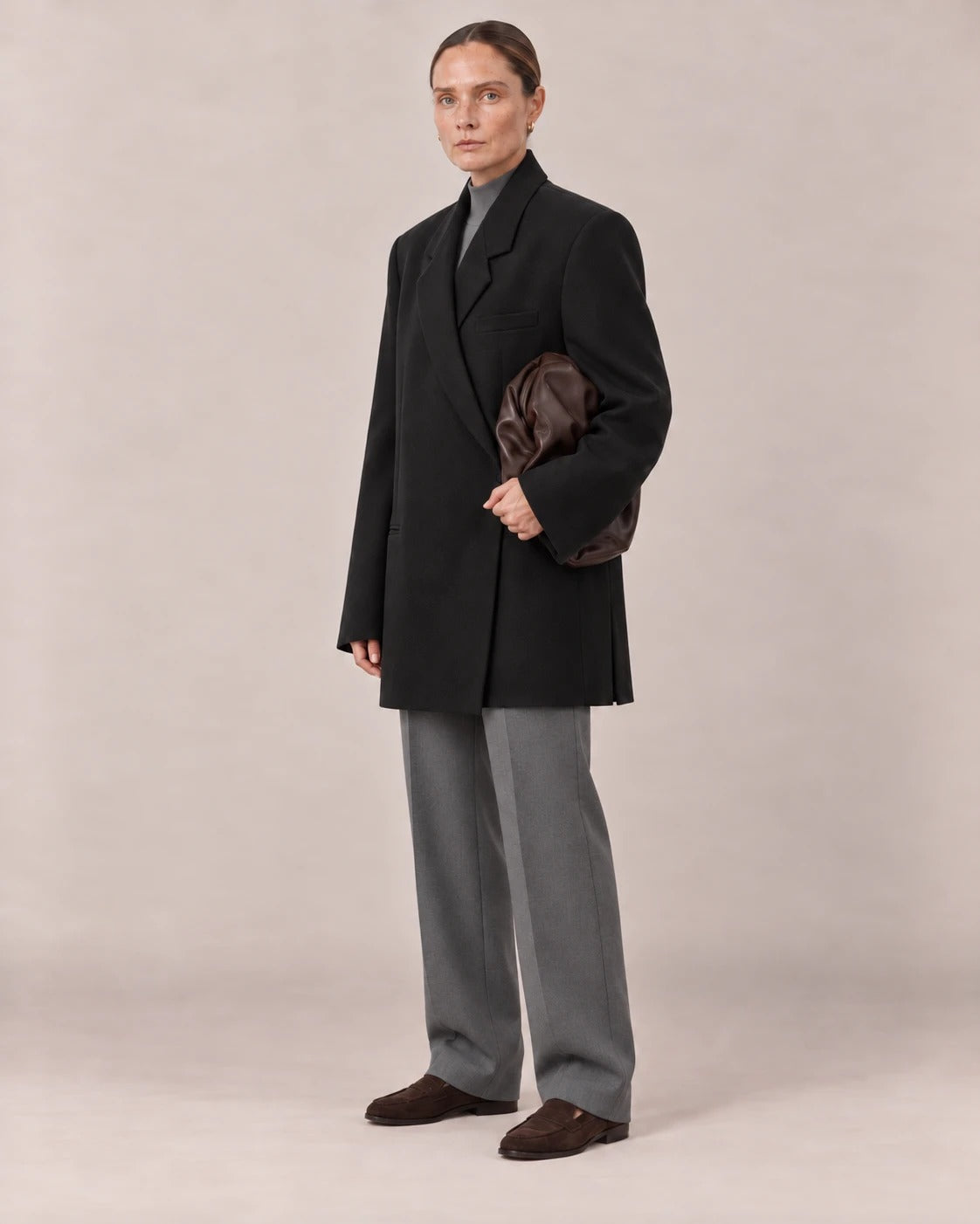 Blazer oversize negro visto de tres cuartos con bolso de piel chocolate