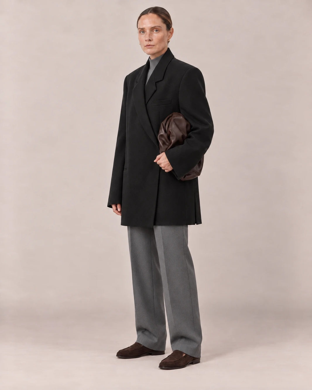 Blazer oversize negro visto de tres cuartos con bolso de piel chocolate