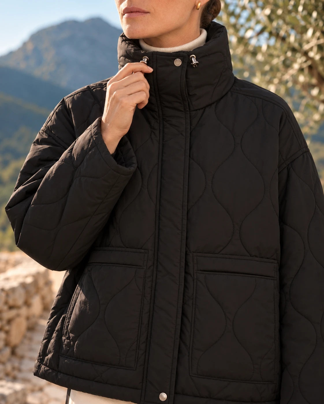 Detalle del cuello con topes plateados y del bolsillo del chaquetón negro
