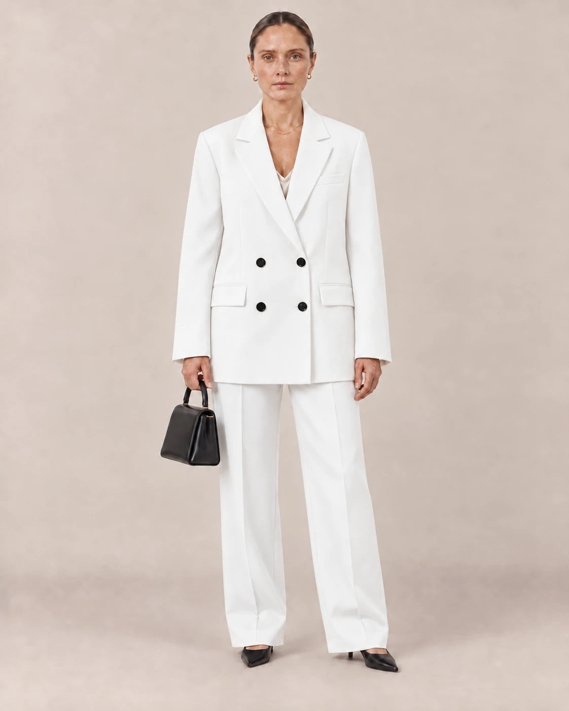 Traje blanco de americana cruzada con botones negros y pantalón ancho