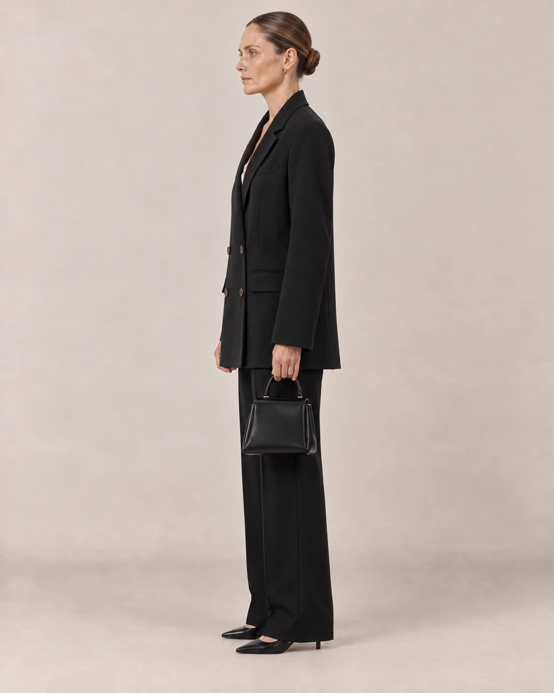Perfil del traje negro con americana oversize larga y pantalón ancho