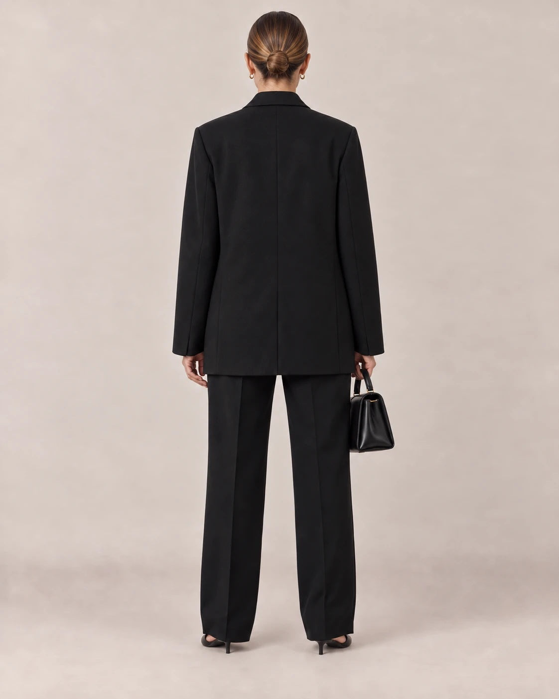 Espalda del traje negro de americana cruzada y pantalón ancho